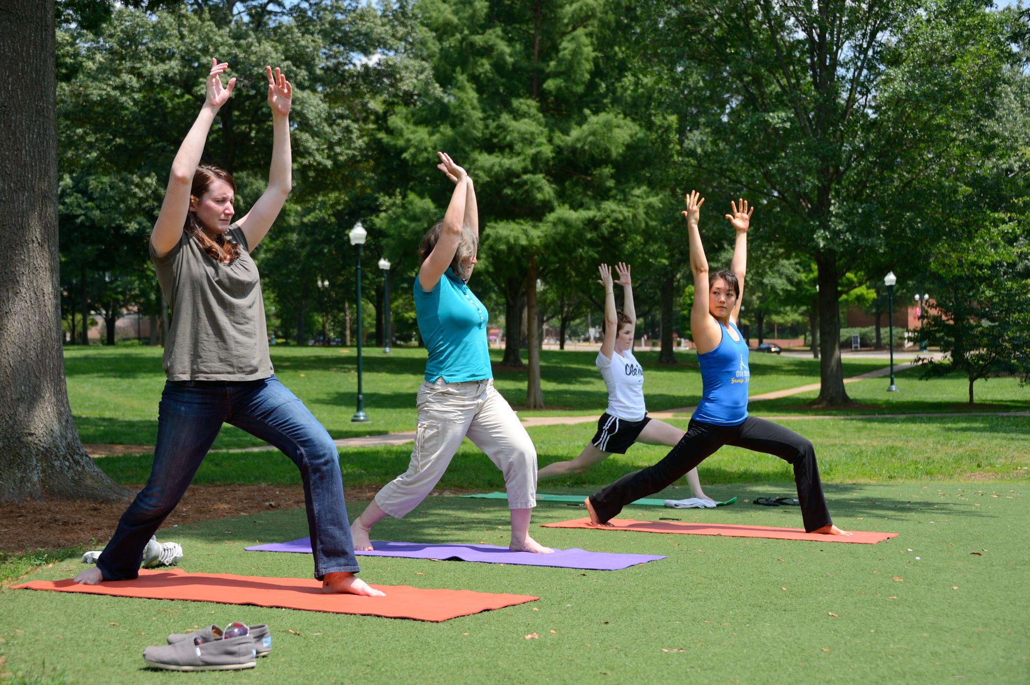 YOGA IN THE GROVE - Ole Miss grad student Eun Ha (Jenny) Kim (right) leads a group of staff members in Yoga exercises in the Grove as part of Staff Appreciation Week. Photo by Robert Jordan/University Communications