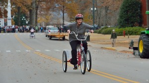 Dr. Brandi Hephner LaBanc rides a tricycle in a relay race as part of the RebelWell program. 