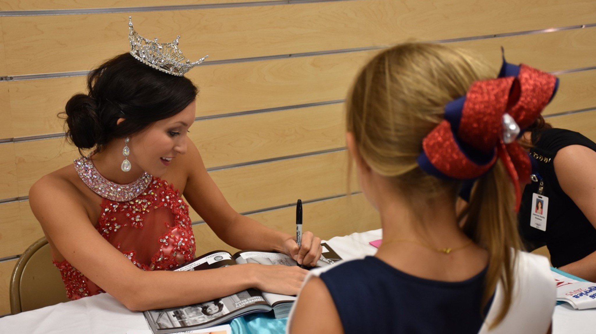Miss University, France Beard, signs autographs for a future Rebel at an autograph party in Vicksburg. France is competing this week in Vicksburg at the Miss Mississippi Pageant. 