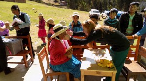 Laken Burrell fits a patient with reading glasses.
