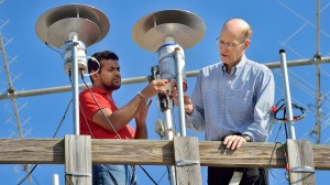 UM physicists Sampath Bandara (left) and Thomas Marshall place a light sensor in place as part of their study of lightning strikes. (Photo by Robert Jordan, UM Imaging Services)