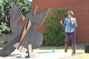 Mia Kaplan giving an outdoor lecture on her process of creating "Swamp Flower"
